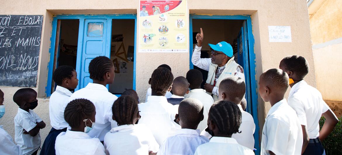 Um oficial da UNICEF WASH explica as medidas de prevenção do Ebola a um grupo de alunos de uma escola primária em Bunia, República Democrática do Congo.