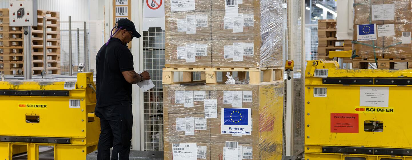 Un travailleur dans un entrepôt emballe des boîtes de fournitures d'urgence financées par l'Union européenne pour la réponse de l'UNICEF à l'épidémie d'Ebola en République démocratique du Congo.