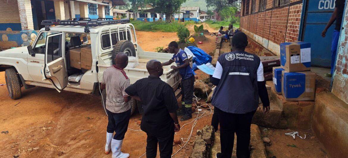 Des travailleurs de l'OMS déchargent des fournitures d'un véhicule dans une clinique en RDC.