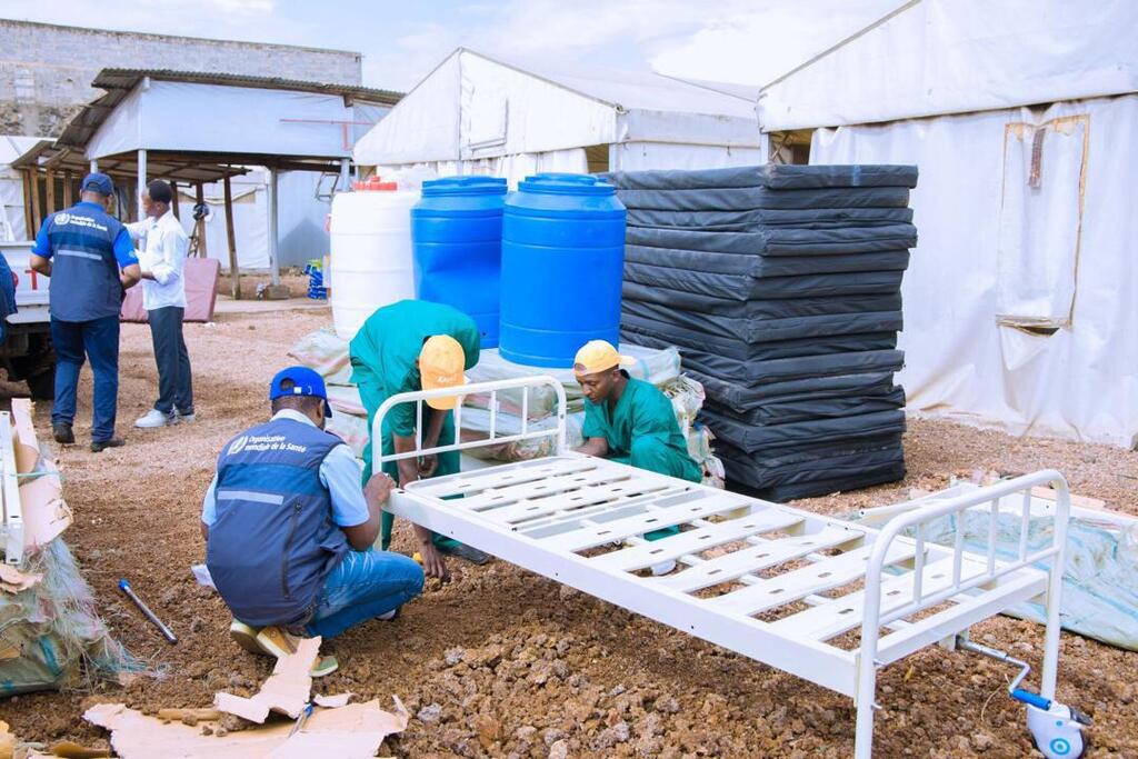 Des travailleurs humanitaires de l'OMS assemblent un lit d'hôpital dans un hôpital de campagne en République démocratique du Congo dans le cadre de la réponse d'urgence à l'épidémie d'Ebola.