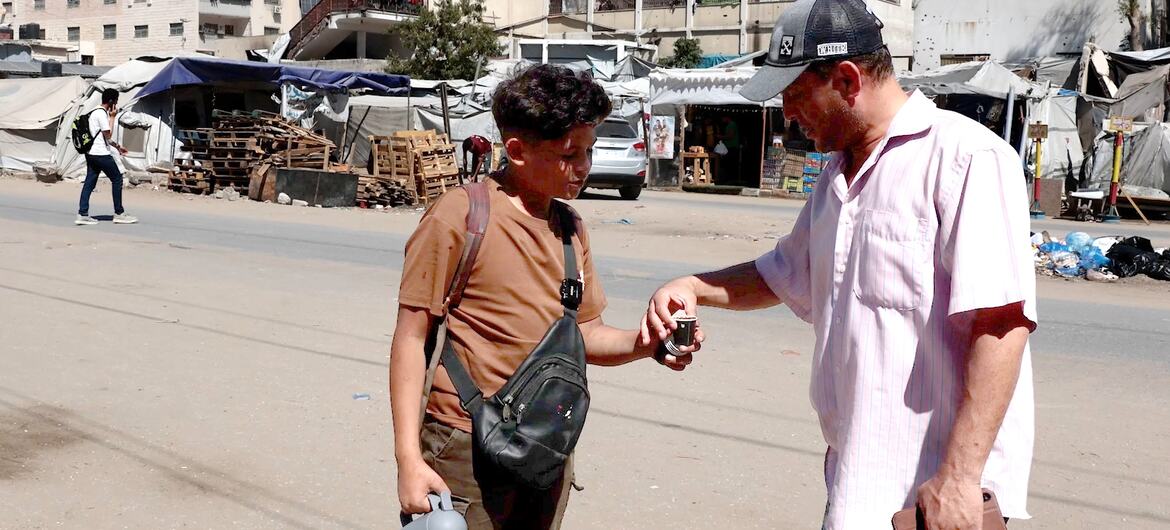 يبيع صبي فلسطيني قهوة لرجل في شارع في غزة خلال عيد الأضحى.