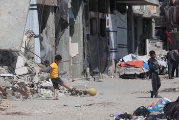 Niños juegan al fútbol entre los escombros en la ciudad de Gaza.