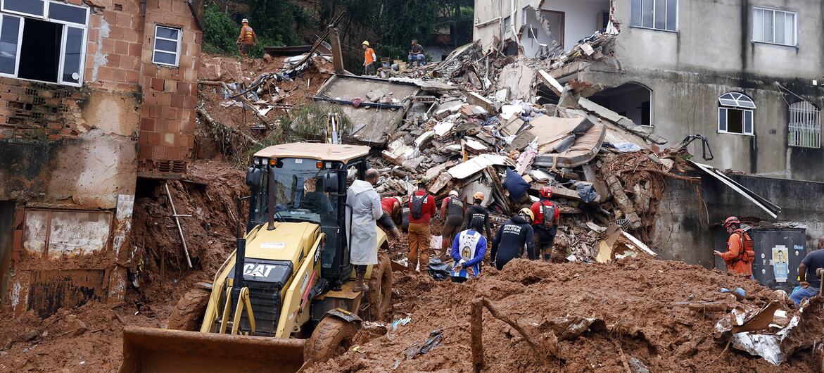 Soldados do Departamento de Bombeiros e voluntários conduzem uma operação de resgate em meio aos escombros de casas enterradas sob lama após fortes chuvas em Juiz de Fora, Brasil.