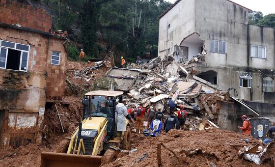 Soldados do Departamento de Bombeiros e voluntários conduzem uma operação de resgate em meio aos escombros de casas enterradas sob lama após fortes chuvas em Juiz de Fora, Brasil.
