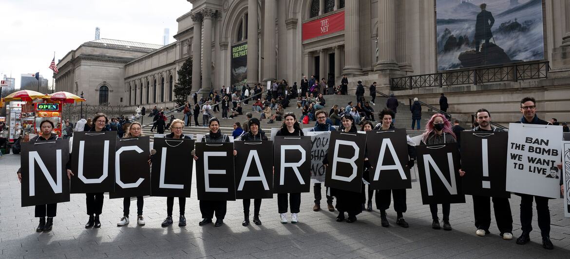 Des manifestants tenant de grandes pancartes sur lesquelles sont inscrits « BAN NUCLEAR ! » et « BAN THE BOMB WE WANT TO LIVE » lors d'une manifestation anti-nucléaire au Metropolitan Museum of Art à New York.