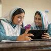پاکستان میں دو مسکراتی لڑکیاں کلاس روم کے ماحول میں ٹیبلٹ کا استعمال کرتے ہوئے سندھ لرننگ پاسپورٹ پہل کو اجاگر کر رہی ہیں جو نوجوان سیکھنے والوں کو بااختیار بناتی ہے۔