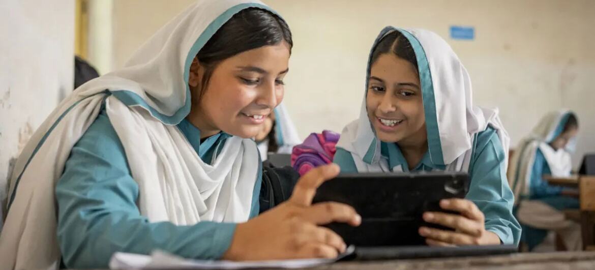 پاکستان میں دو مسکراتی لڑکیاں کلاس روم کے ماحول میں ٹیبلٹ کا استعمال کرتے ہوئے سندھ لرننگ پاسپورٹ پہل کو اجاگر کر رہی ہیں جو نوجوان سیکھنے والوں کو بااختیار بناتی ہے۔