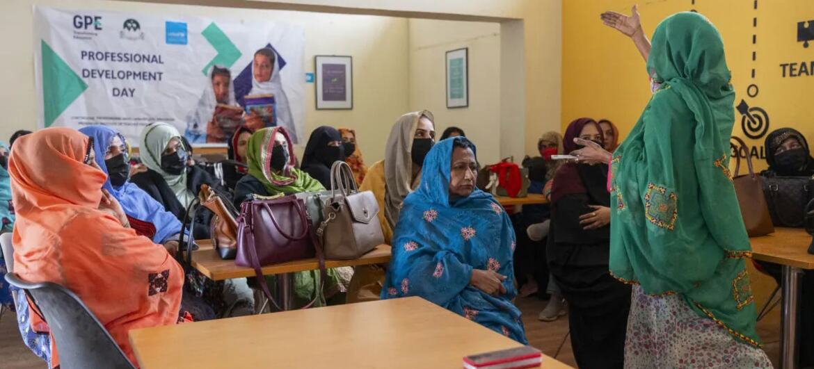 پاکستان کے بلوچستان میں جی پی ای اور یونیسیف کی حمایت میں پیشہ ورانہ ترقی کے دن کے موقع پر سبز حجاب پہنے ایک خاتون نے ایک کلاس روم کے ماحول میں خواتین کے ایک گروپ سے بات کی۔