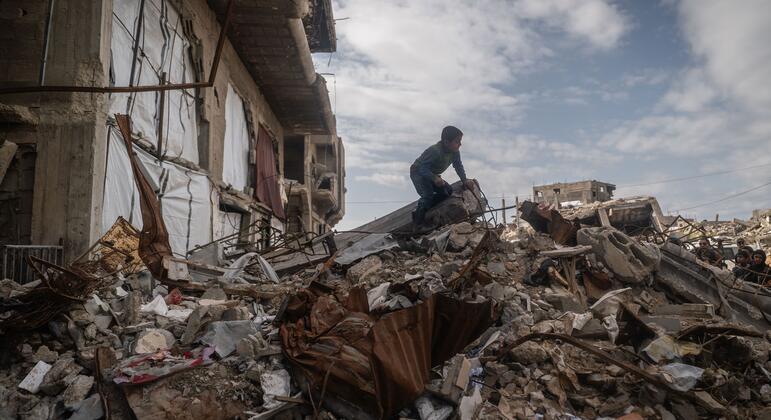 Un enfant traverse les décombres de bâtiments détruits à Beit Lahia, à Gaza, soulignant la dévastation et les efforts humanitaires en cours.