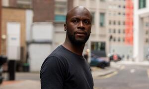 Picha ya Deo Kato, mwanariadha anayeshirikiana na Shirika la Kimataifa la Uhamiaji nchini Afrika Kusini, akiwa amesimama kwenye barabara ya jiji.