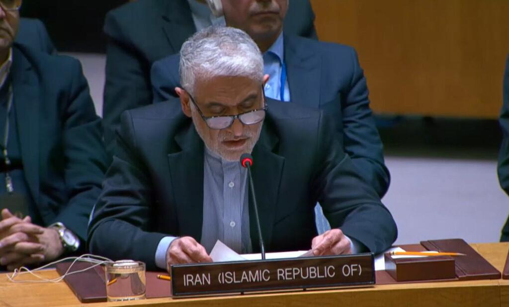 Iran's Ambassador Amir Saeid Iravani address the Security Council. A male diplomat from Iran (Islamic Republic of) speaking at an international conference, reading from a document at a podium with his country's nameplate.