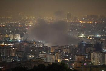 Un paysage urbain nocturne de Téhéran, en Iran, avec de la fumée provenant d'un incendie dans la zone urbaine.
