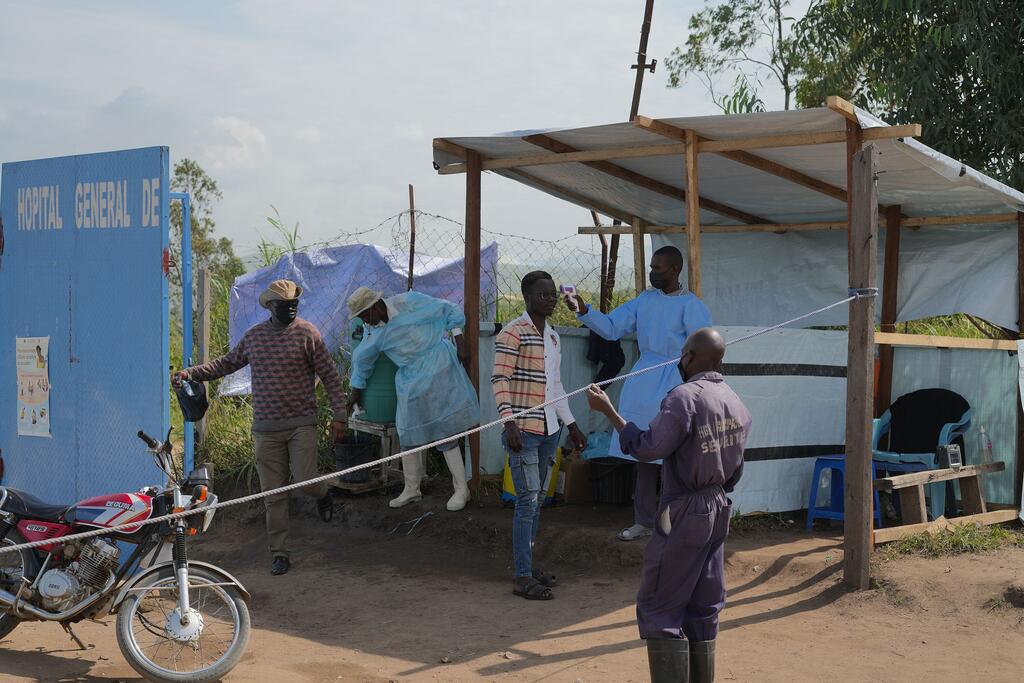 Timu za afya za umma zilizovaa mavazi ya kinga zinashughulikia mlipuko wa Ebola kwenye mlango wa Hospitali ya Rwampara ya Urefu wa Kijamii katika Mkoa wa Ituri, Jamhuri ya Kidemokrasia ya Kongo.