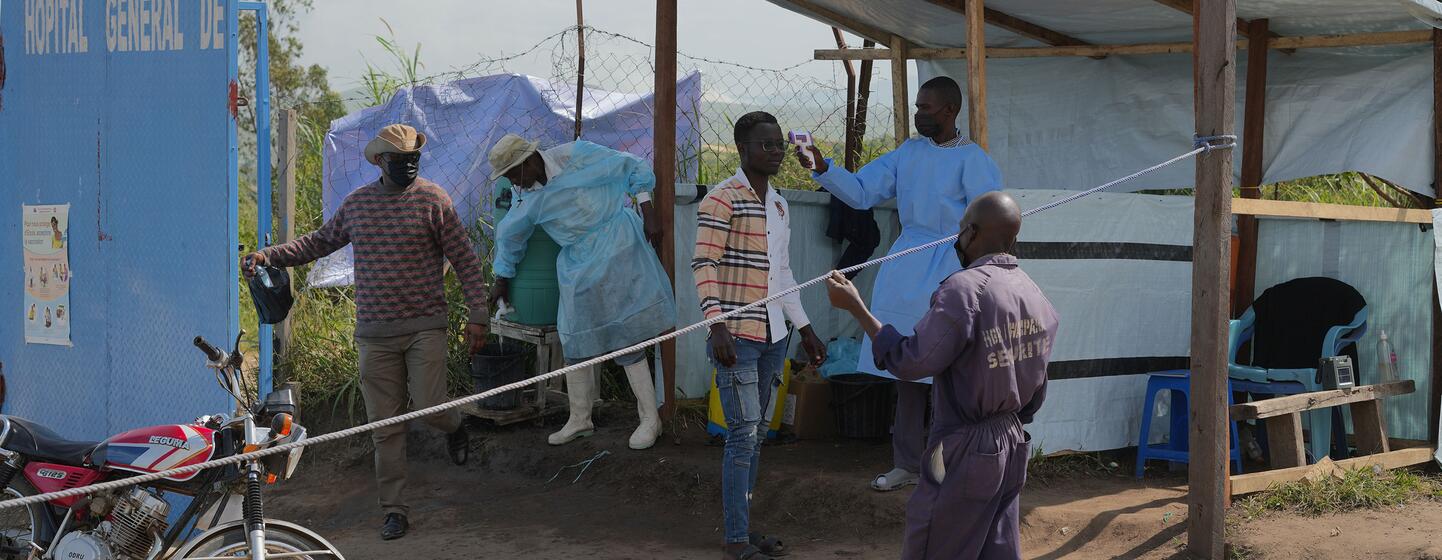 Des équipes de santé publique en équipement de protection gèrent une réponse à l'épidémie d'Ebola à l'entrée de l'hôpital général de référence de Rwampara, dans la province d'Ituri, en RDC.
