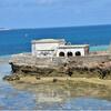 Forte histórico de pedra numa costa rochosa em Moçambique, com o oceano e um céu azul claro ao fundo.