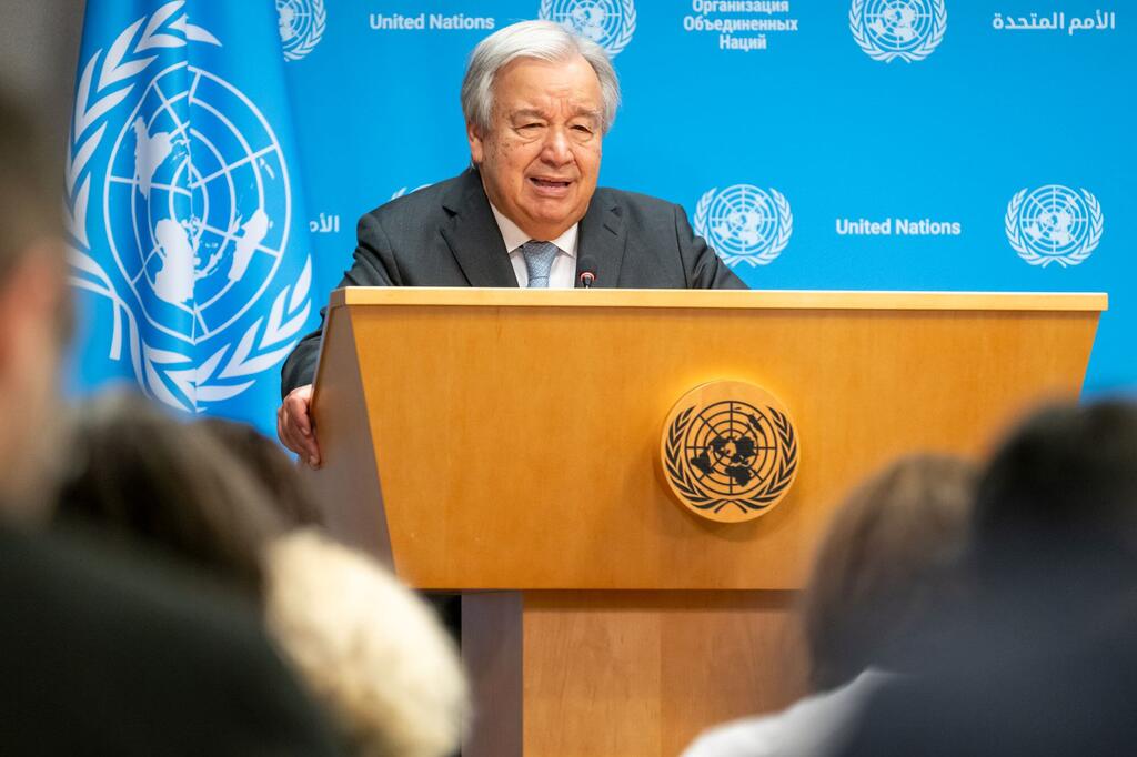 Le secrétaire général des Nations Unies, António Guterres, tient une conférence de presse sur les impacts de la chaleur extrême et de la crise climatique dans son ensemble, debout sur un podium avec le logo de l'ONU.