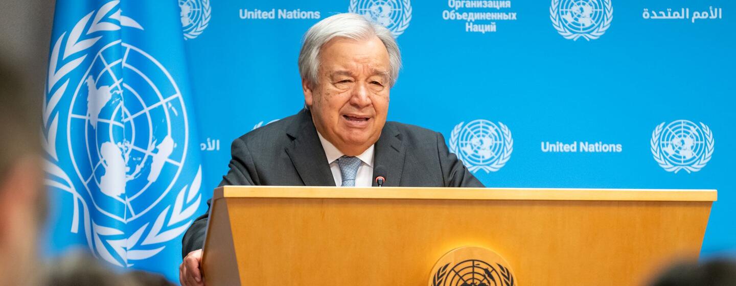 Le secrétaire général des Nations Unies, António Guterres, tient une conférence de presse sur les impacts de la chaleur extrême et de la crise climatique dans son ensemble, debout sur un podium avec le logo de l'ONU.