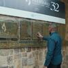 Mwanamume akigusa bamba la ukumbusho la kusherehekea wenzake wa Umoja wa Mataifa waliopoteza maisha wakati wa mauaji ya kimbari Rwanda 1994, chini ya bendera ya 'Kwibuka 32'.