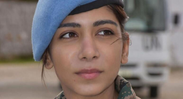 Portrait of Major Abhilasha Barak, an Indian Army peacekeeper, wearing a blue UN beret and camouflage uniform.