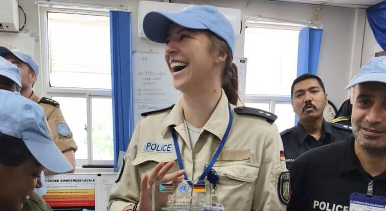 UN Woman Police Officer of the Year Stephanie Königs of Germany holds an award in a UNMISS office, surrounded by colleagues.