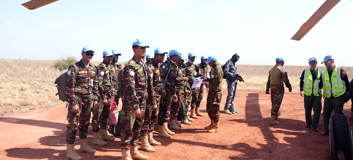 联和国驻苏丹阿卜耶伊临时安全部队（UNISFA）维和士兵在一条红土路上排成一列，在直升机下接受指令。
