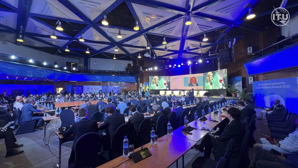 Los asistentes a la Cumbre Internacional de Resiliencia de Cables Submarinos 2025, organizada por la UIT, se sentaron en una gran sala de conferencias con pantallas que muestran altavoces.