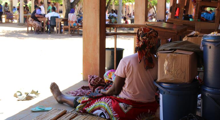 Uma mulher deslocada está sentada no chão de uma escola em Xai-Xai, Moçambique, após inundações recentes.