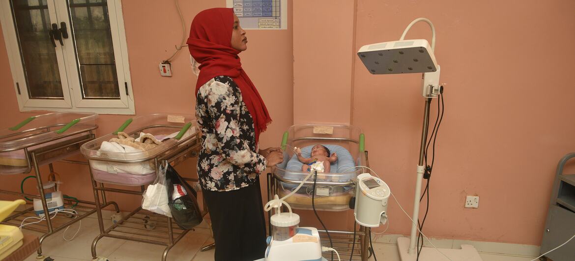 A midwife in a red hijab monitors a newborn baby in an incubator at El Obeid Maternity Hospital in Sudan. The hospital opened a new neonatal unit in 2026 with only four beds, highlighting the urgent need for expanded capacity.