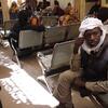 Um refugiado sudanês está sentado em uma sala de espera lotada em um centro de registro do ACNUR no Egito.
