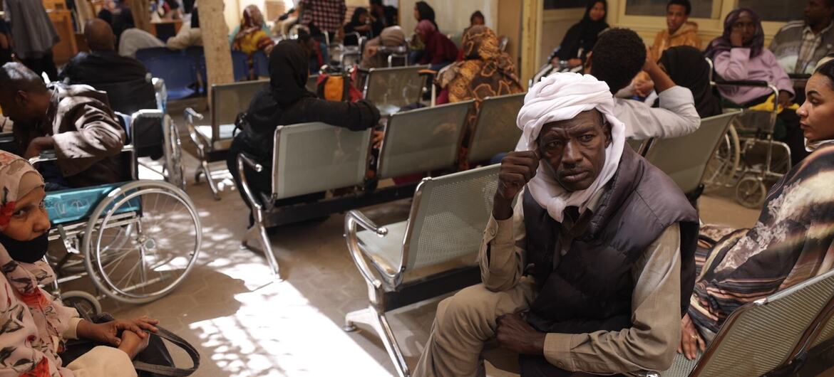 يجلس لاجئ سوداني في غرفة انتظار مزدحمة في مركز تسجيل مفوضية الأمم المتحدة لشؤون اللاجئين في مصر.