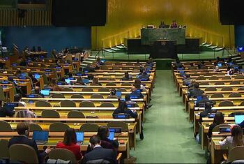 La cinquième commission de l'Assemblée générale des Nations unies, réunie dans une grande salle de conférence avec des délégués assis en rangées, travaillant sur des ordinateurs portables, se concentre sur les questions administratives et budgétaires.