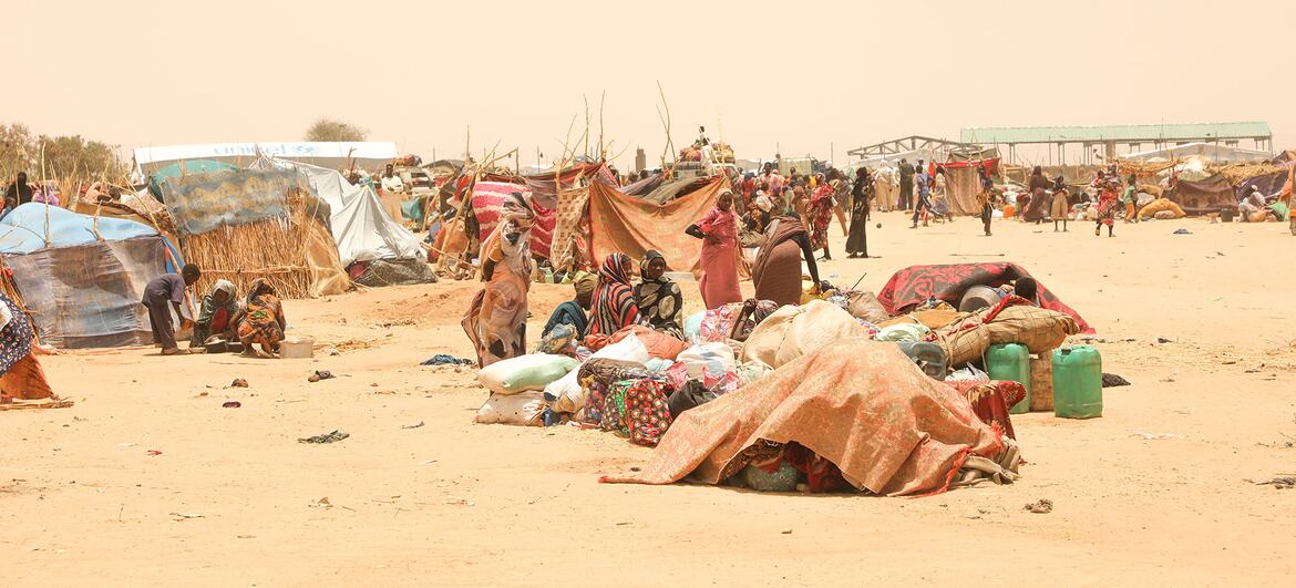 Sudanese refugees displaced by conflict gather in Tiné, Chad, waiting for relocation to a temporary site amid scarce resources and harsh conditions.
