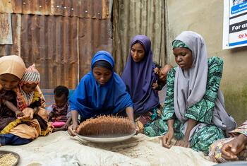 Des mères à Maiduguri, au Nigeria, trient des grains de millet, de maïs et de soja pour un supplément nutritif soutenu par le PAM pour lutter contre la malnutrition chez les enfants.