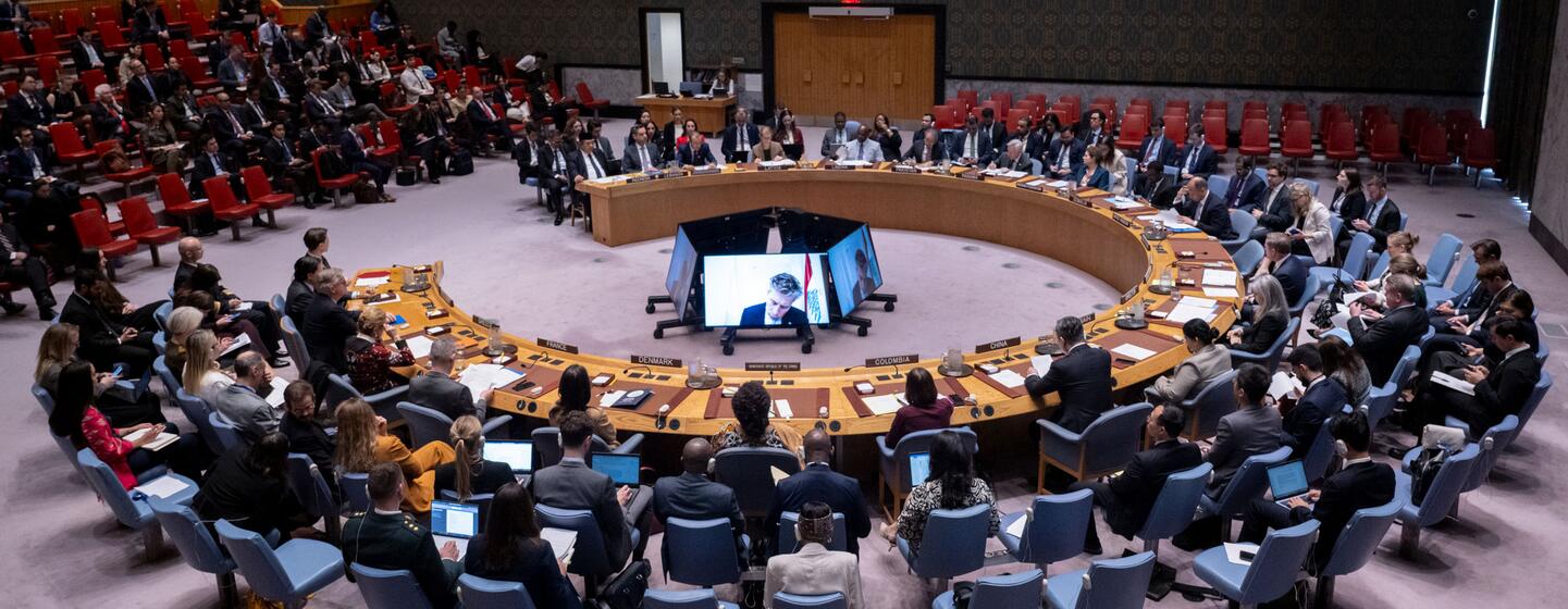 Vue large de la salle du Conseil de sécurité des Nations Unies lors d'une réunion d'urgence concernant la situation au Liban. Les délégués sont assis autour de la table de fer à cheval emblématique, avec des membres de l'auditoire en arrière-plan.