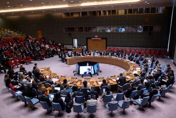 关于黎巴嫩局势的紧急会议期间,联合国安理会会议室的广景.代表坐在标志性的马桌周围,背景是观众. 中央的屏幕显示演讲者.
