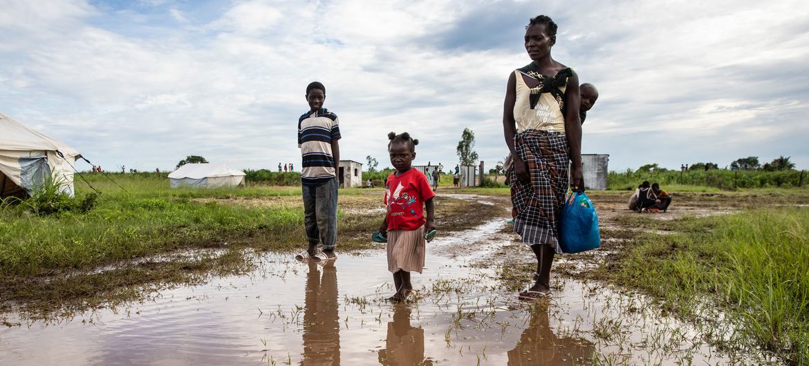 A family affected by Cyclone Eloise walk through a flooded area at a relocation centre in Sofala Province in Mozambique.