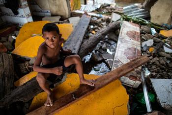 Um menino está sentado nos escombros de sua casa que foi destruída pelo furacão Iota em Bilwi, Nicarágua.