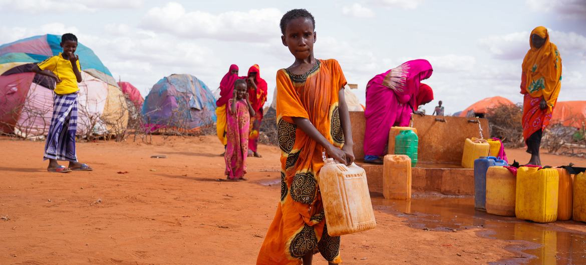 فتاة صغيرة تحمل الماء في مخيم للنازحين في دولو بالصومال.