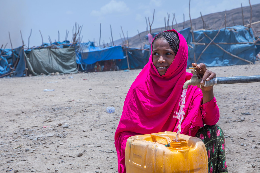 فتاة نازحة تجلب الماء من نقطة توزيع مياه في مخيم للنازحين في أفار بإثيوبيا.