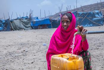 Una niña desplazada saca agua de un punto de agua en un campo de desplazados en Afar, Etiopía.