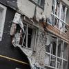 Prédio de apartamentos destruído em Bucha, na Ucrânia, com janelas quebradas e marcas de tiros.