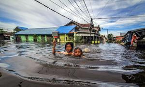 Children wade through flood water in Palangka Raya, in Central Kalimantan, Indonesia.