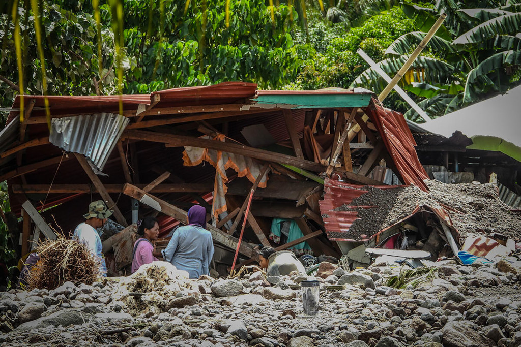 Los residentes sobrevivientes de una aldea de reubicación en Barangay Kusiong, Datu Odin Sinsuat, Maguindanao, se encuentran entre los escombros de su casa dañada después de un deslizamiento de tierra causado por el tifón Paeng.