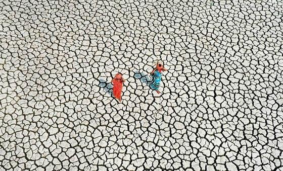 En una tierra gravemente afectada por la sequía, dos mujeres buscan su suministro diario de agua.