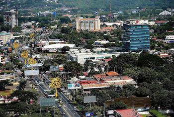 Aerial view of Managua, Nicaragua, showing a mix of modern and traditional buildings, busy streets, and green areas.