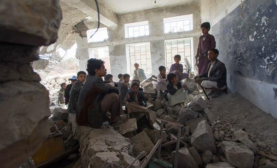 在也门萨达市，孩子们坐在被毁坏的学校里的一间旧教室里。
