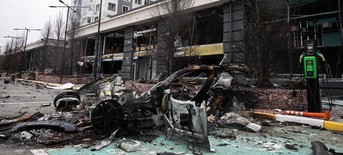 Une voiture détruite et des bâtiments endommagés à Bucha, en Ukraine.