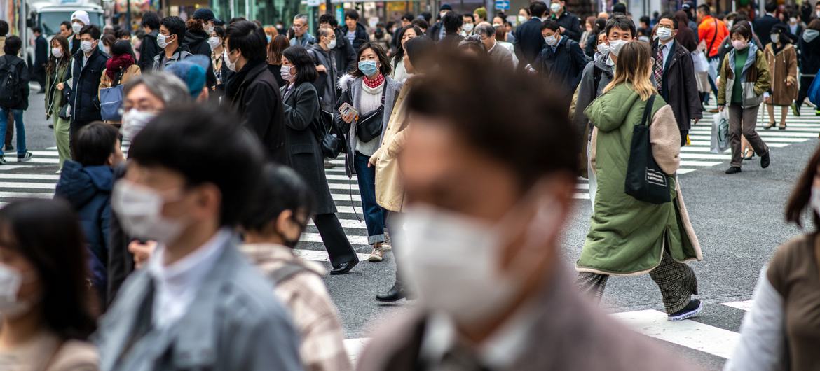يرتدي الناس أقنعة واقية في طوكيو، اليابان.