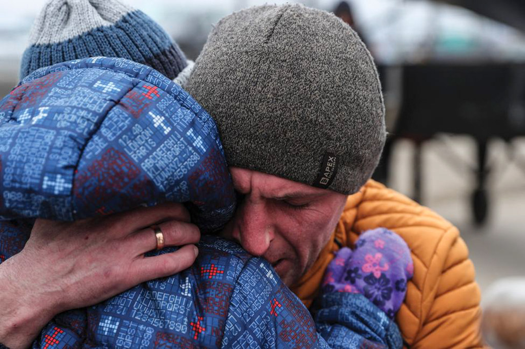 Un padre se despide de su hijo y el resto de su famlia tras llevarlos hasta la frontera y tener que regresar a Ucrania