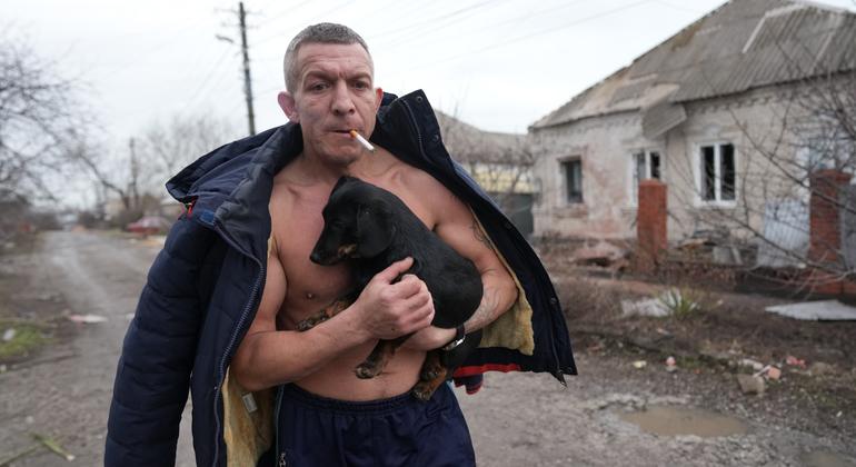 Un hombre, con su perro en brazos, camina entre las casas destrozadas tras un bombardeo en Mariupol, en el sureste de Ucrania.